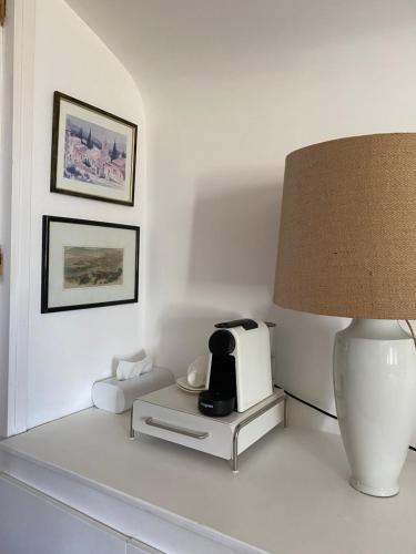 a white table with a lamp and a coffee maker on it at Villa les Palmiers in Calcatoggio