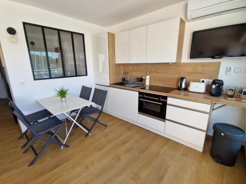 une petite cuisine avec une table et une table et des chaises dans l'établissement Très belle marina plein sud, au Grau-du-Roi