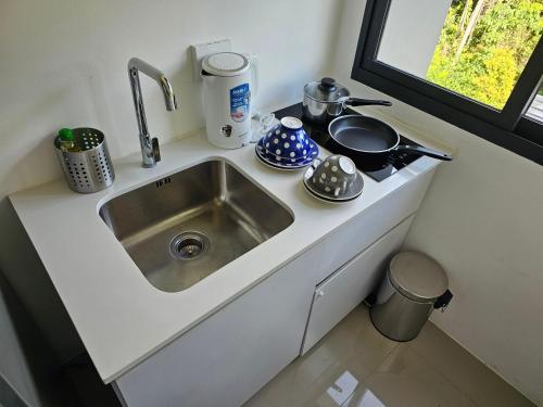 a kitchen counter with a sink and a stove at Aya Residence Garden View in Ban Ket Ho