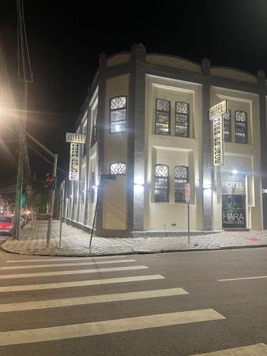 a building on the corner of a street at night at Hara Palace Hotel in Curitiba