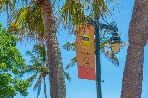 a street light with a sign next to a palm tree at Sarasota Updated pool home, Near Siesta Key in Sarasota