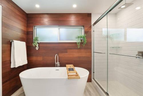 a bathroom with a white tub and a glass shower at Sarasota Updated pool home, Near Siesta Key in Sarasota