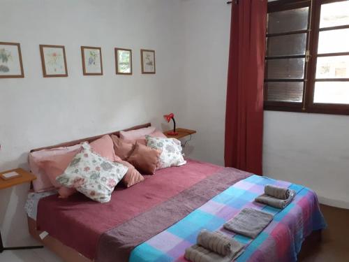 Un dormitorio con una cama con almohadas. en Casa condomínio paz en Petrópolis