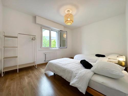 a white room with two beds and a window at Castelview - Sion next to the old town in Sion