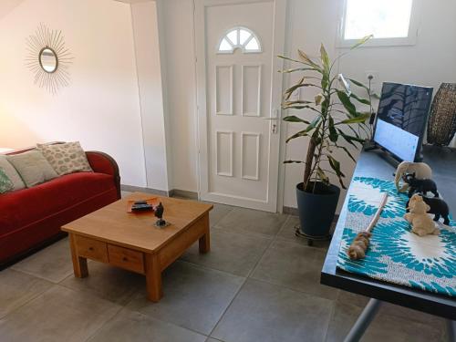 un salon avec un canapé rouge et une table basse dans l'établissement Pause nature au cœur du parc naturel du Médoc, à Moulis-en-Médoc