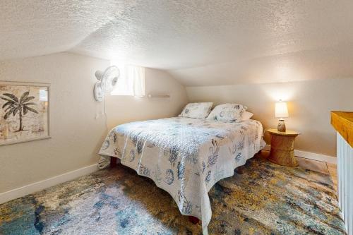 1 dormitorio con 1 cama con edredón blanco en Bunglow Boogie Bunkhouse, en New Port Richey
