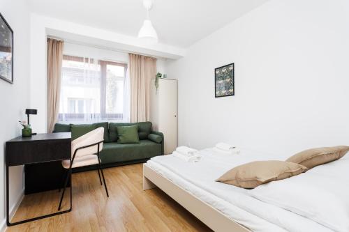 een slaapkamer met een bed, een bureau en een bank bij Pretty 4 Bedroom Apartment x Parking Spot x City Center in Krakau