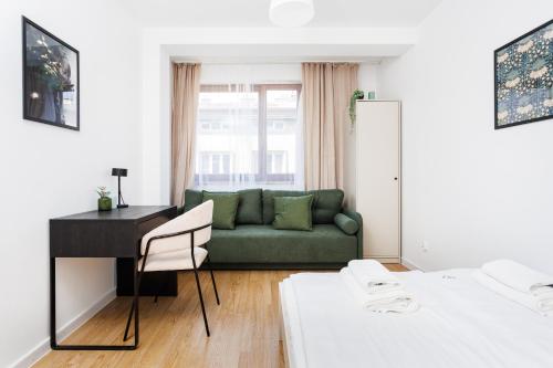 een woonkamer met een groene bank en een bureau bij Pretty 4 Bedroom Apartment x Parking Spot x City Center in Krakau