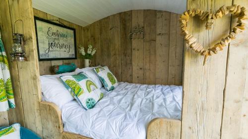 a bedroom with a bed in a wooden house at Ynys Hideout in Moelfre