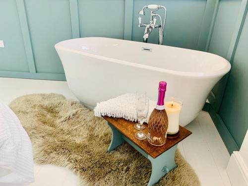 a bathroom with a white tub and a sink at The Coach House in Matlock