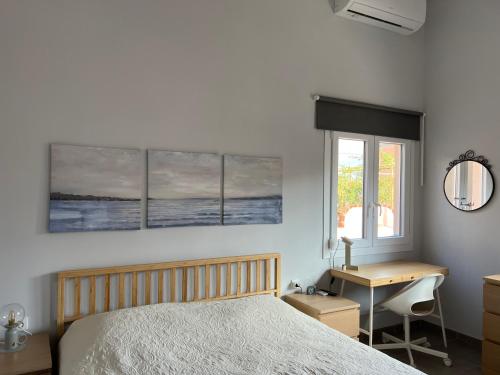 a bedroom with a bed and a desk and a window at Avli Luxury Apartment in Ierissos