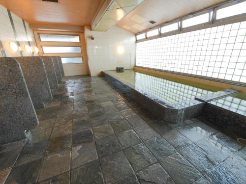 a bathroom with a row of seats and a swimming pool at APA Hotel Takasaki Ekimae in Takasaki