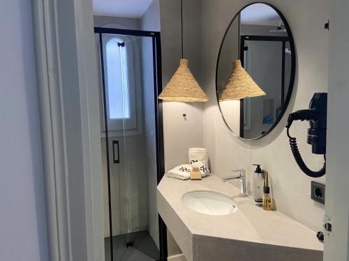 W łazience znajduje się umywalka i lustro. w obiekcie Calendula Hotel w Sant Feliu de Guixols