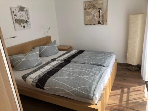 una camera da letto con un grande letto con lenzuola e cuscini grigi di Fewo Rhein-Lahn OG2-2 a Lahnstein