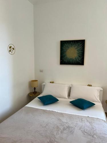 1 dormitorio con 1 cama blanca y 2 almohadas azules en Fior di Loto Suite - Antonelli, en Turín