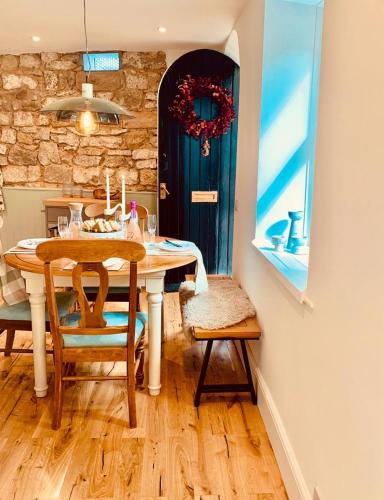 a dining room with a table and chairs and a door at The Coach House central location fantastic Views in Matlock