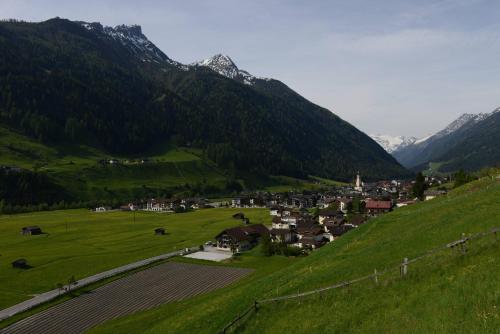 a small town in a green valley with mountains at Haus Elisabeth in Neustift im Stubaital