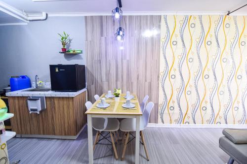 a dining room with a table and a kitchen at GoldMine Staycation in Manila