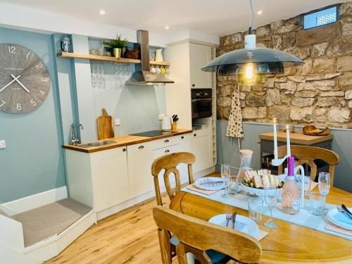 cocina con mesa de madera con sillas y comedor en The Coach House en Matlock