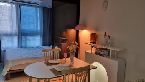 um quarto com uma mesa e um quarto com uma cama em Mia House em Daegu