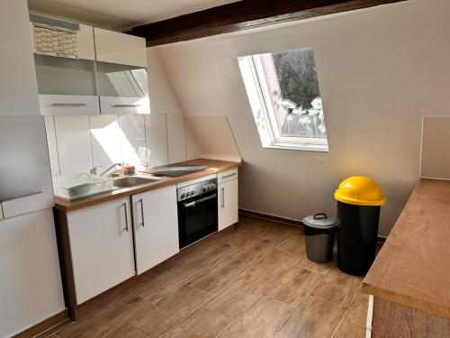 eine Küche mit weißen Schränken, einem Waschbecken und einem Fenster in der Unterkunft Monteurunterkunft Schwarzenbruck in Schwarzenbruck