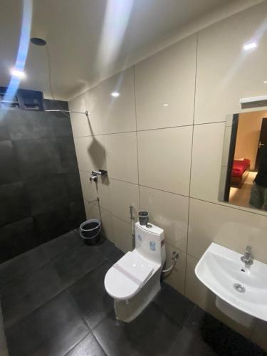 a bathroom with a toilet and a sink at Redbell Suites Kizhisseri in Kondotti