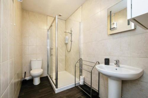 a bathroom with a shower and a toilet and a sink at 3- Bedroom modern,spacious apartment-Devon in Newton Abbot