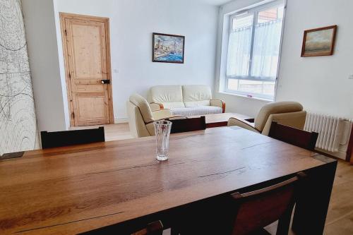 a living room with a wooden table with a glass at Villa Marine*La Capitainerie in Coudekerque-Branche