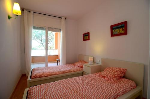 1 dormitorio con 2 camas y ventana en Puig sa Guilla 1C B3, en Pals