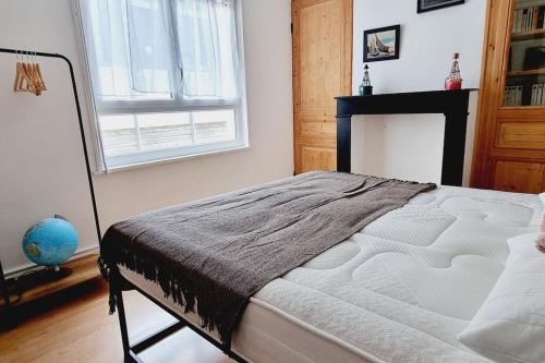 a bedroom with a bed and a fireplace and a window at Villa Marine*La Capitainerie in Coudekerque-Branche
