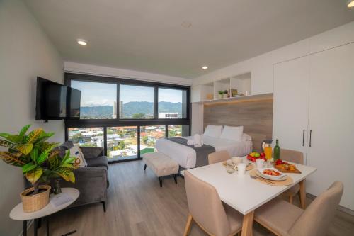 una sala de estar con una cama y una mesa con comida. en BEE Suites Escalante en San José