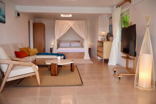 a living room with a bed and a couch at Blue Whale Villa - Deluxe Suite in Calibishie