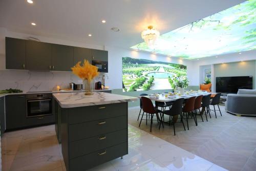 une cuisine et une salle à manger avec une table et des chaises dans l'établissement Triplex 250m² 6CH - Clim - Très spacieux -, à Paris