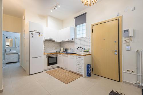 a kitchen with white appliances and a large doorway at Alimos Marina Beach Apartment in Athens