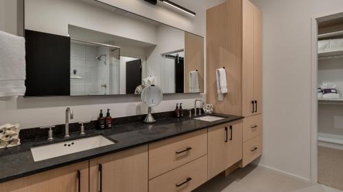 a bathroom with two sinks and a large mirror at Butterfly Lofts - West in Steamboat Springs