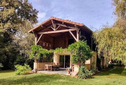 - un pavillon avec une table et des chaises dans un jardin dans l'établissement The Lake Cottage in Gascony France, à Créon-dʼArmagnac