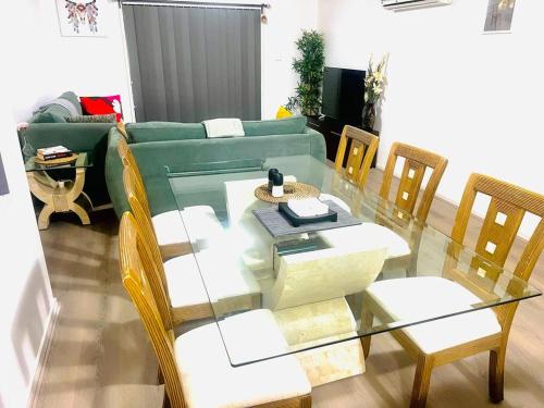 sala de estar con mesa de cristal y sofá verde en 3 BR Ngunnawal, en Hall