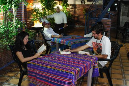 un grupo de personas sentadas en mesas en un restaurante en Hostal Suites Madrid, en Guayaquil