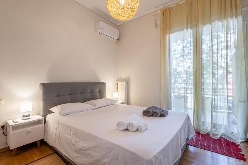 - une chambre avec un lit blanc et des serviettes dans l'établissement Alimos Marina Beach Apartment, à Athènes