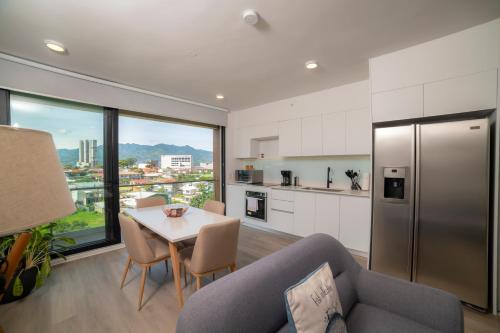 a kitchen and dining room with a table and a refrigerator at BEE Suites Escalante in San José