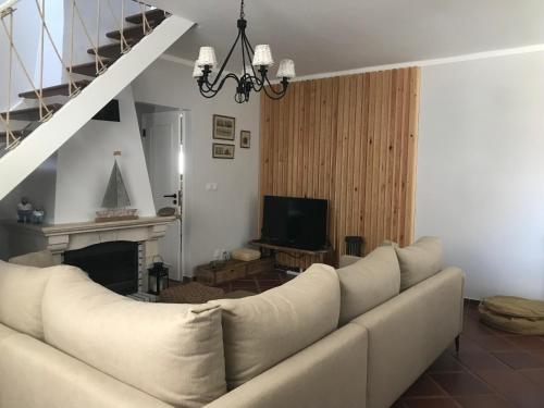 ein Wohnzimmer mit einer weißen Couch und einem Kamin in der Unterkunft Casa da Ilha do Baleal in Baleal