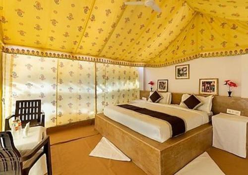 1 dormitorio con 1 cama con techo amarillo en Hotel Golden Night Jaisalmer, en Jaisalmer