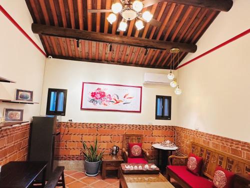 uma sala de estar com uma parede de tijolos e um tecto em 時光旅舍古厝一館 em Jinning
