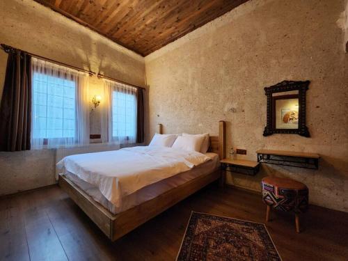 a bedroom with a large bed and a large window at Key of Cappadocia - House of Eos in Avanos
