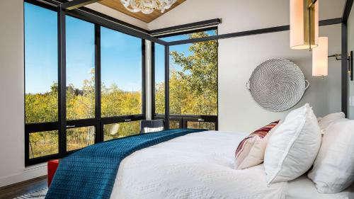 a bedroom with a large bed and large windows at Chalet Cascada in Steamboat Springs