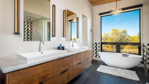 a bathroom with two sinks and a large window at Chalet Cascada in Steamboat Springs