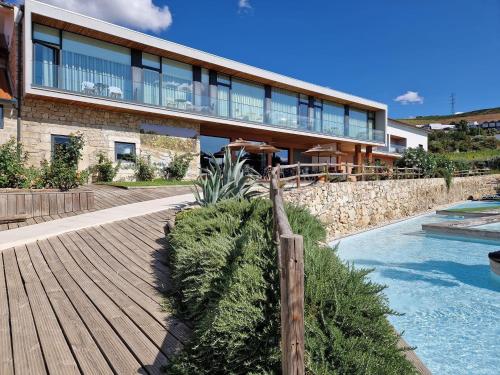 uma casa com um passadiço de madeira junto a uma piscina em Douro Cister Hotel Resort em Ucanha