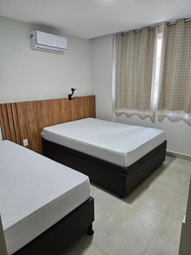 a bedroom with two beds and a window at Apto frente mar 3 suites Castelhanos ES in Anchieta