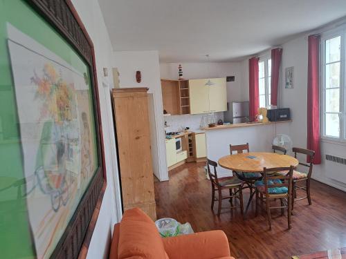 uma sala de estar com uma mesa e uma cozinha em Loft vue imprenable sur le vieux Saintes em Saintes