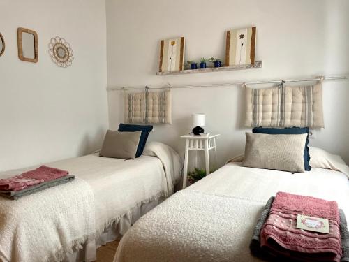 two beds in a room with white walls at SANTA LUCÍA Garaje privado in Zamora